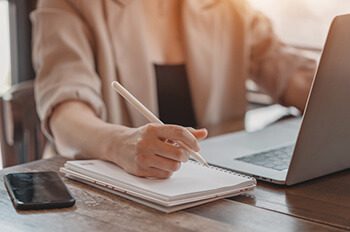 Woman hands holding pen and working with documents.Hands at work with Digital Technology.Working on desk environment.