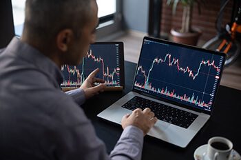 Man Checking His Stock Market Exchange Investment Using His Laptop Computer.